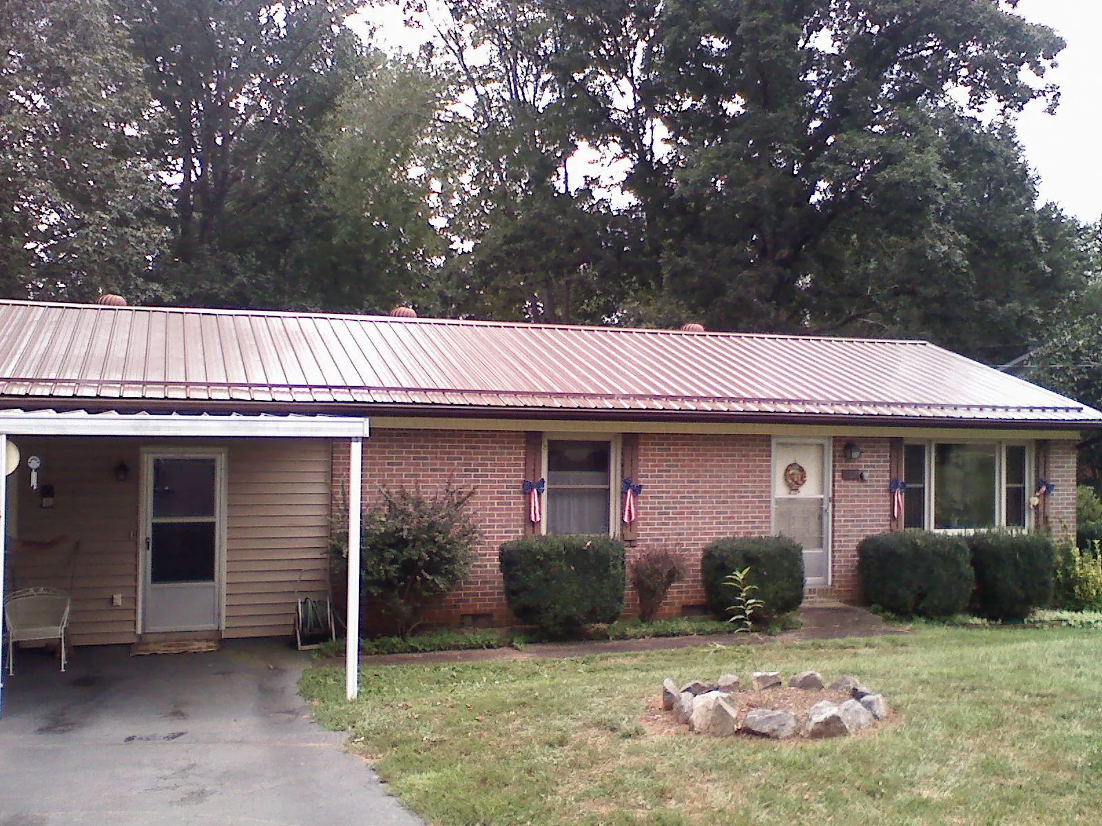 Bronze metal roof and carport on a brick ranch home — Roof Repair work by our crew in Lockwood